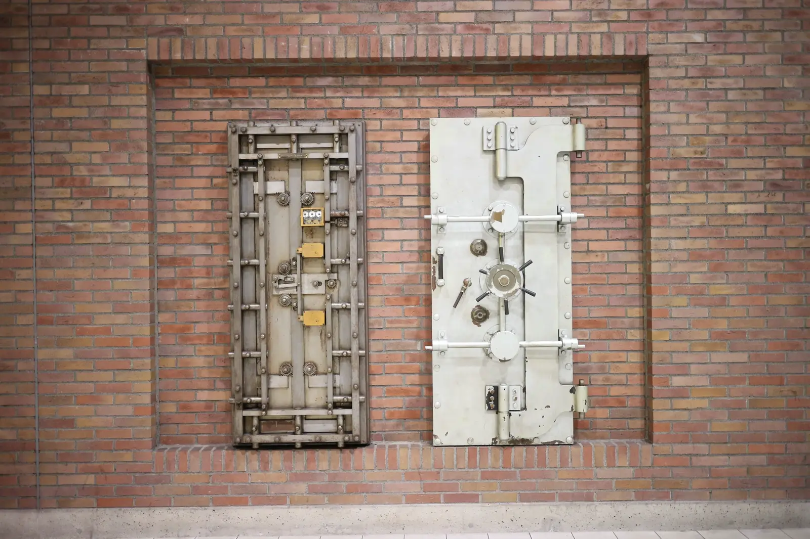Two heavy steel vault doors set into a brick wall.