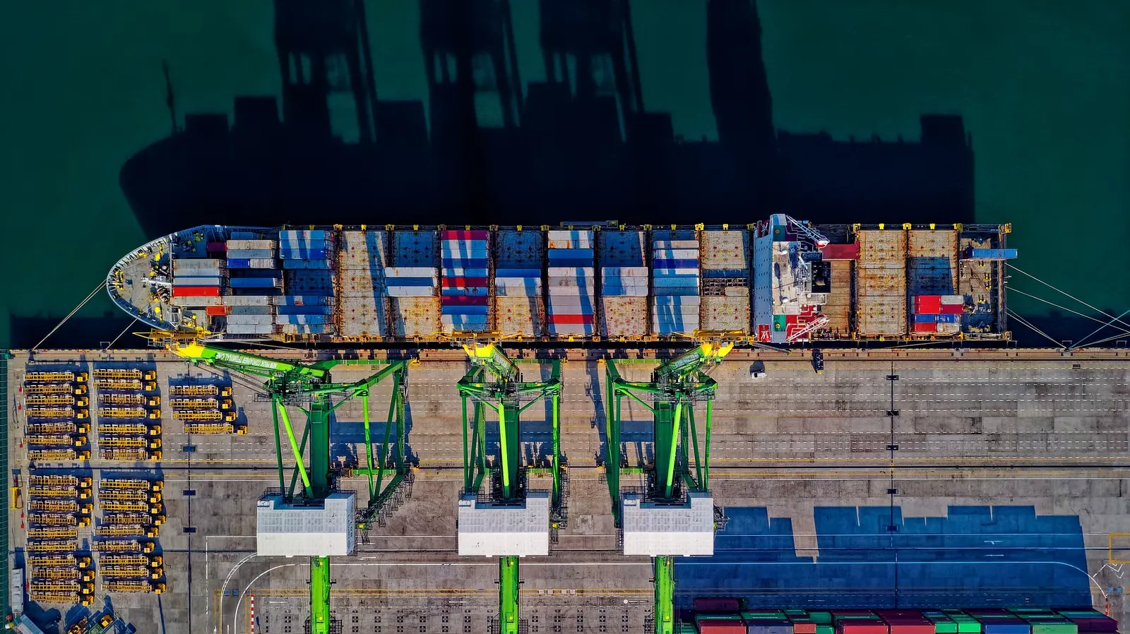 A container ship being worked at berth, straight down from above.