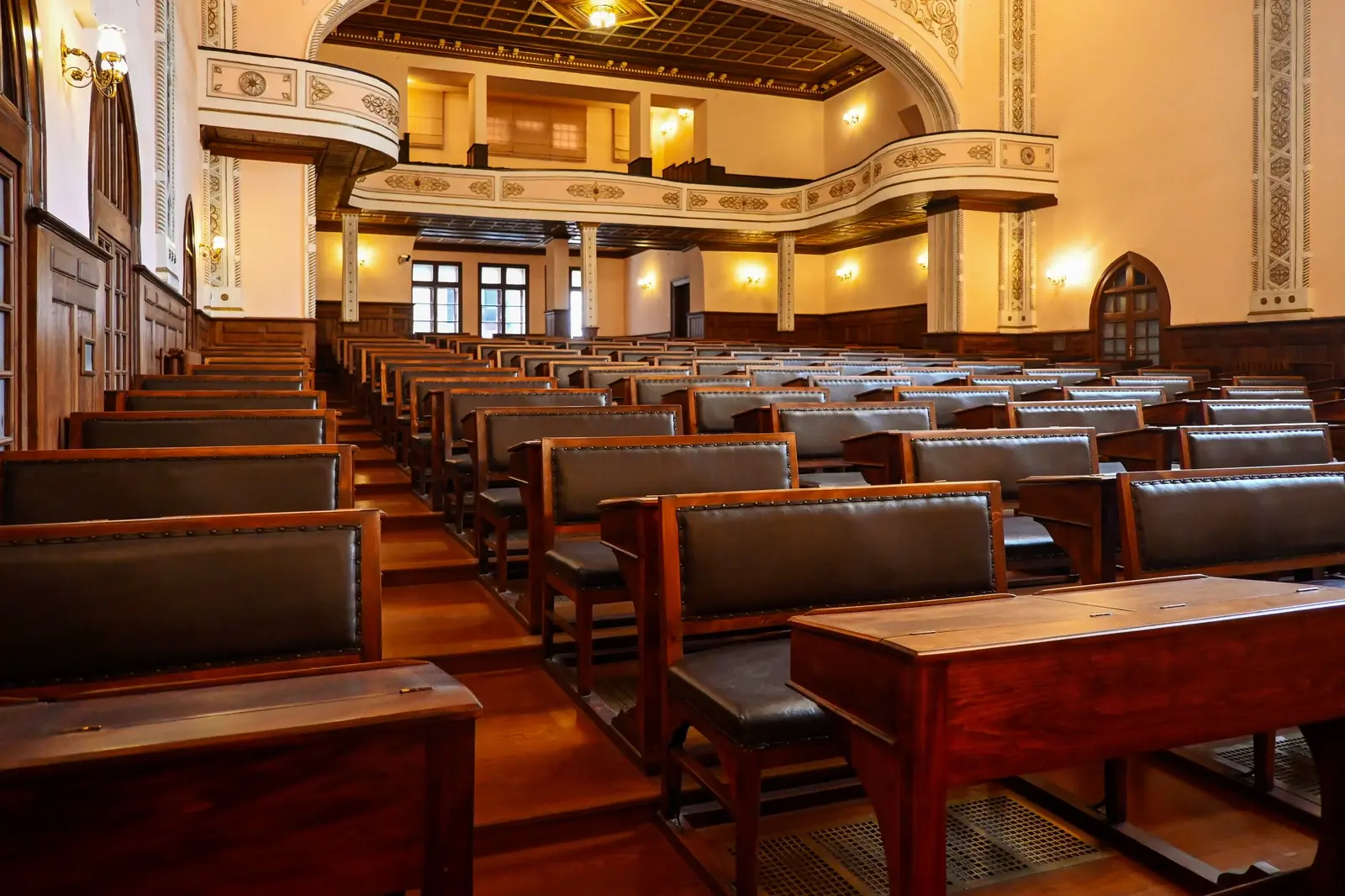 A historic university lecture hall with tiered wooden benches.