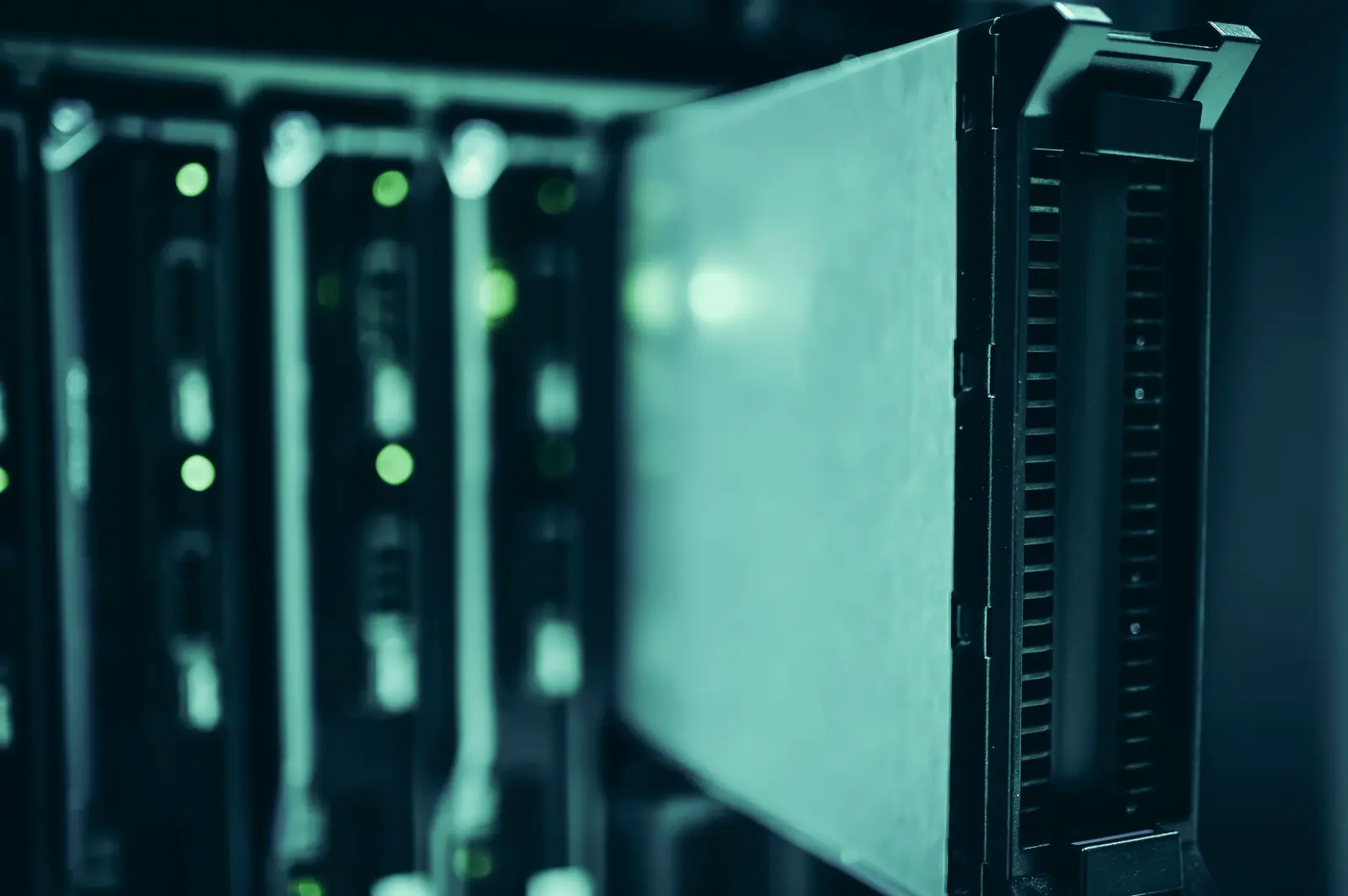 Blade servers with active status lights in a darkened data-centre rack.