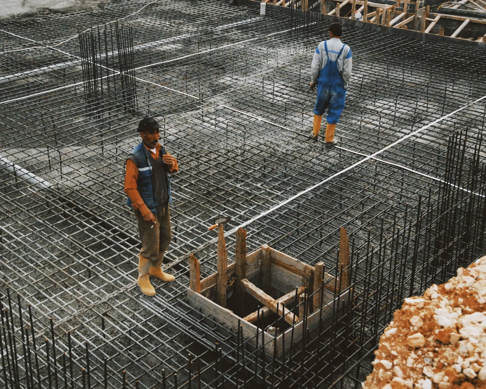 Crews working reinforcement steel across a foundation deck.